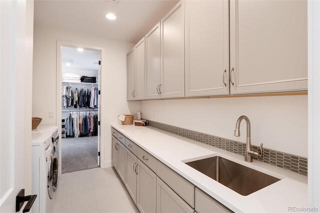 kitchen with sink, light colored carpet, and washing machine and clothes dryer