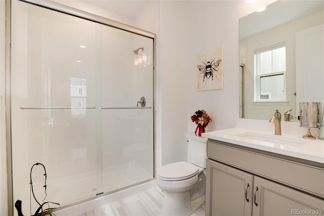 bathroom with toilet, an enclosed shower, and vanity