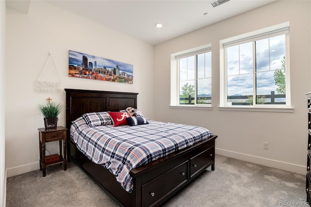 bedroom featuring light colored carpet and multiple windows