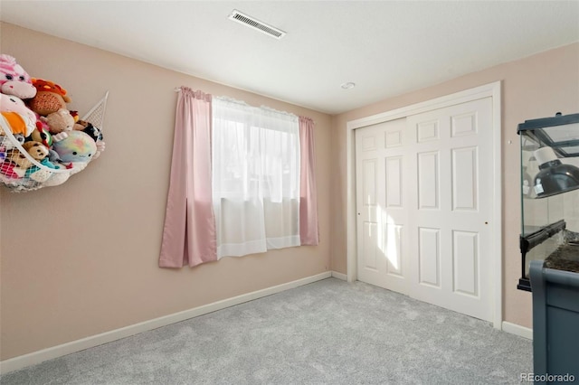 unfurnished bedroom with light carpet and a closet