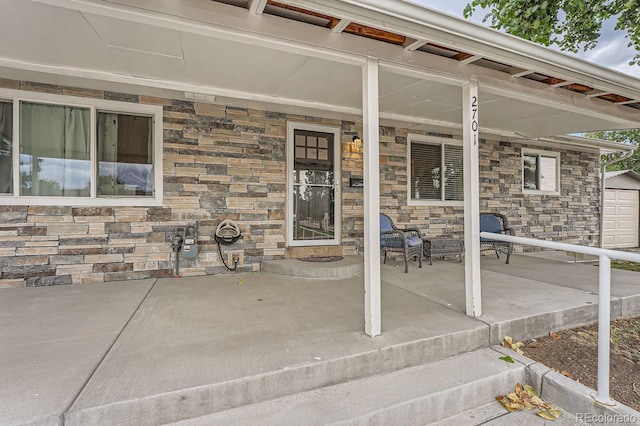 property entrance with covered porch and stone siding