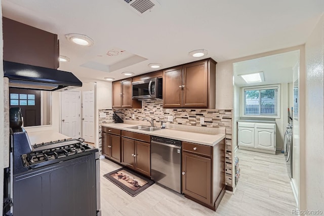 kitchen featuring tasteful backsplash, ventilation hood, sink, dark brown cabinetry, and stainless steel appliances