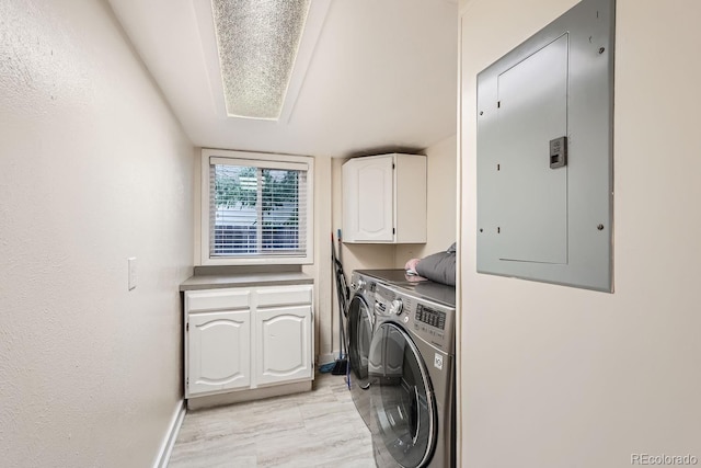 laundry area featuring washer and dryer, electric panel, and cabinets