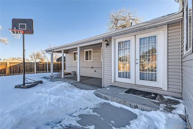 snow covered property entrance featuring french doors