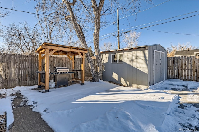 snowy yard featuring a storage unit