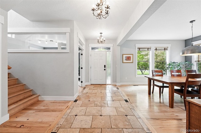 8276 E 28th Dr, Denver, CO 80238 - foyer featuring baseboards, a chandelier, stone tile flooring, and stairway