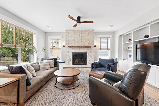8276 E 28th Dr, Denver, CO 80238 - living room featuring ceiling fan, a brick fireplace, light wood-style flooring, and built in features