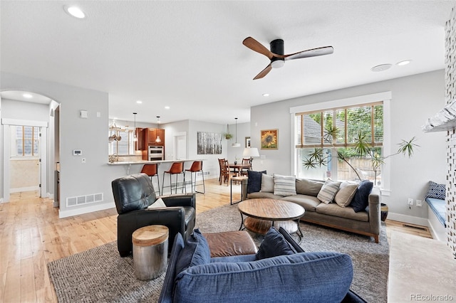 8276 E 28th Dr, Denver, CO 80238 - living area with ceiling fan, arched walkways, light wood finished floors, and recessed lighting