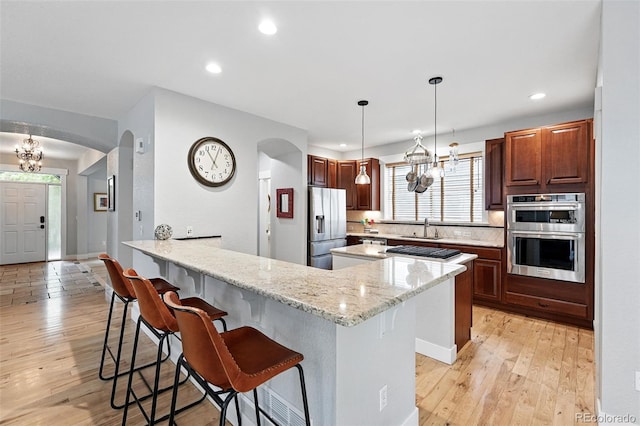 8276 E 28th Dr, Denver, CO 80238 - kitchen featuring stainless steel appliances, arched walkways, a chandelier, and recessed lighting