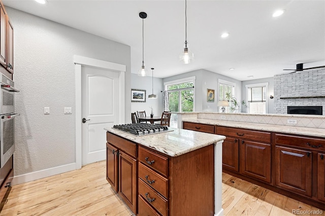 8276 E 28th Dr, Denver, CO 80238 - kitchen with stainless steel appliances, light wood-type flooring, ceiling fan, open floor plan, and light stone counters