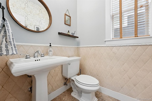 8276 E 28th Dr, Denver, CO 80238 - half bath with tile walls, toilet, a wainscoted wall, and tile patterned floors