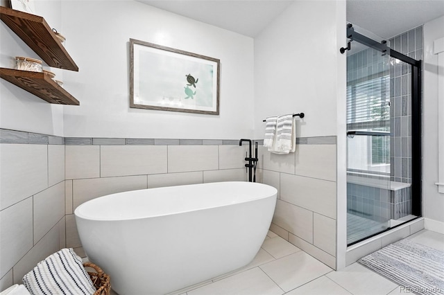 8276 E 28th Dr, Denver, CO 80238 - bathroom with a freestanding bath, a stall shower, tile walls, tile patterned flooring, and a wainscoted wall