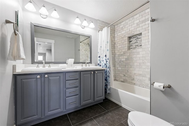 8276 E 28th Dr, Denver, CO 80238 - full bathroom with tile patterned floors, double vanity, toilet, shower / bath combo with shower curtain, and a textured ceiling