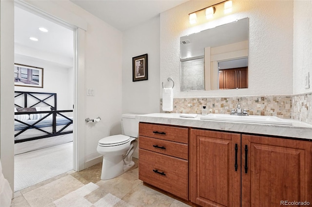 8276 E 28th Dr, Denver, CO 80238 - bathroom with vanity, toilet, and tasteful backsplash