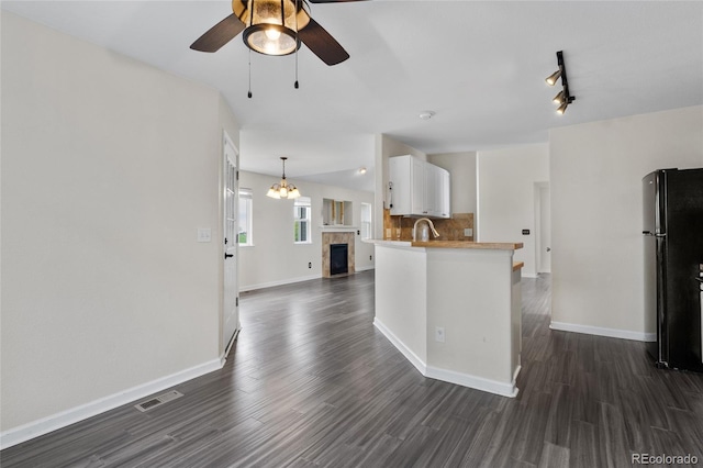 kitchen with freestanding refrigerator, a ceiling fan, white cabinetry, dark wood-style floors, and open floor plan