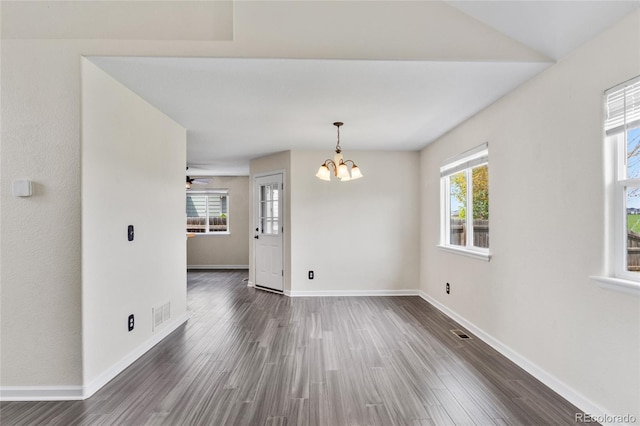 unfurnished dining area featuring wood finished floors, a chandelier, baseboards, and a ceiling fan