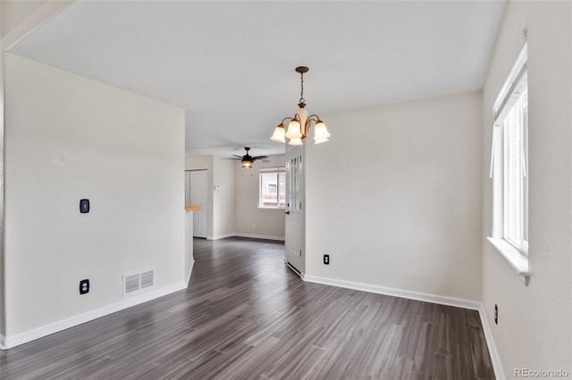unfurnished dining area with a chandelier, baseboards, and dark wood-style floors