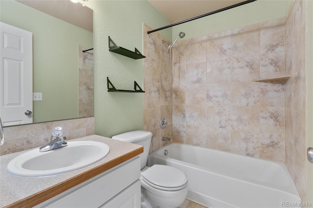 full bathroom with toilet, vanity, a textured wall, and tub / shower combination