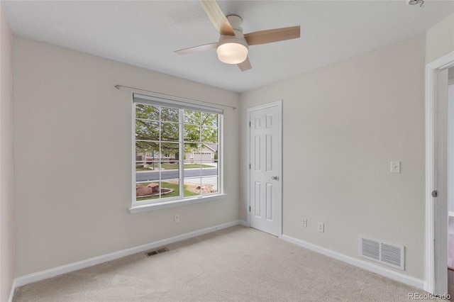 unfurnished room with a ceiling fan, light carpet, and baseboards