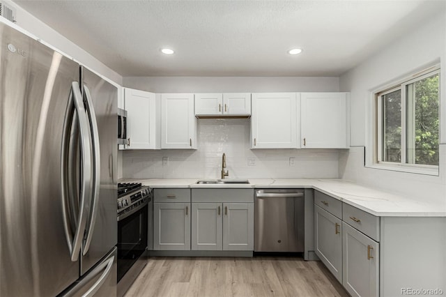 1000 Worchester St, Aurora, CO 80011 - kitchen featuring stainless steel appliances, gray cabinetry, light wood-type flooring, light stone countertops, and recessed lighting