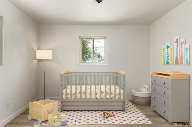 1000 Worchester St, Aurora, CO 80011 - bedroom featuring a crib and wood finished floors