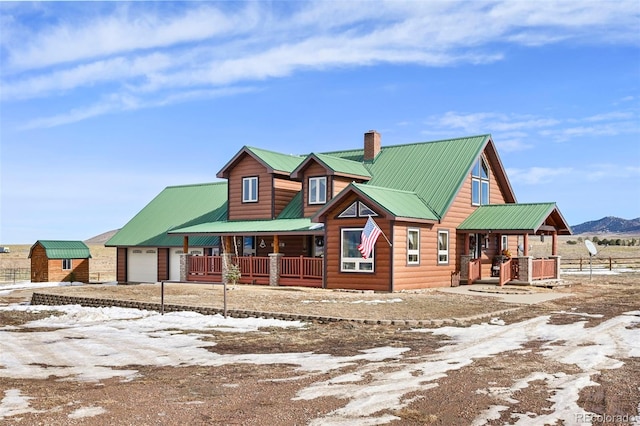 cabin featuring a mountain view, a porch, and an outdoor structure