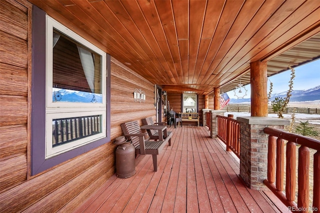 deck with a mountain view and a porch