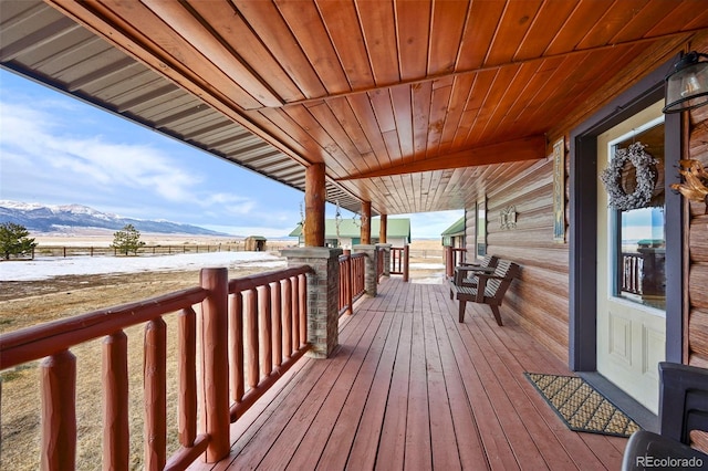 deck with a mountain view and covered porch