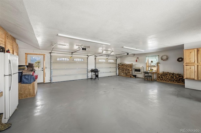 garage with white fridge and a garage door opener