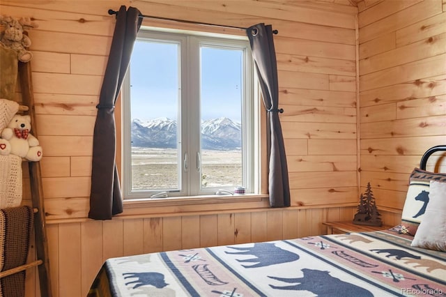 bedroom with a mountain view, multiple windows, and wooden walls