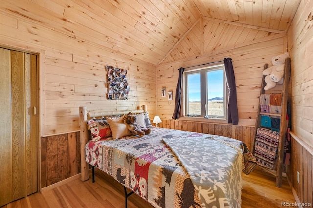 bedroom featuring light hardwood / wood-style flooring, vaulted ceiling, wooden walls, and wood ceiling