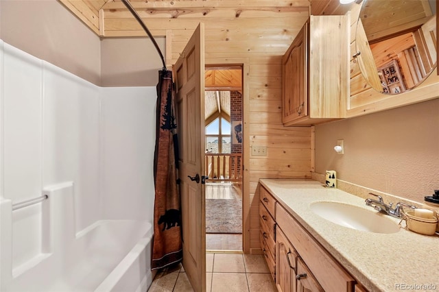 bathroom with tile patterned floors, vanity, wood walls, and shower / bathtub combination with curtain