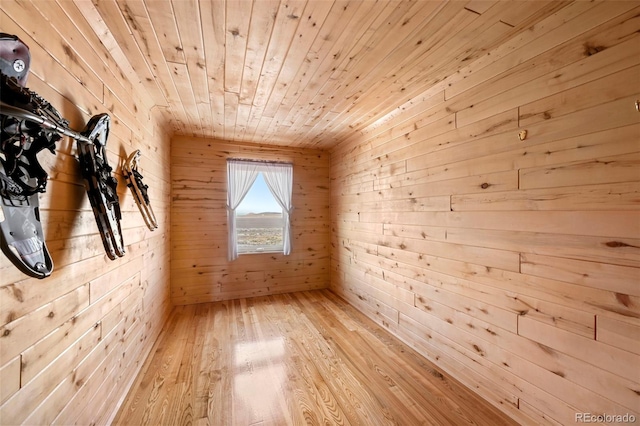 interior space featuring wooden ceiling, wooden walls, and light hardwood / wood-style flooring