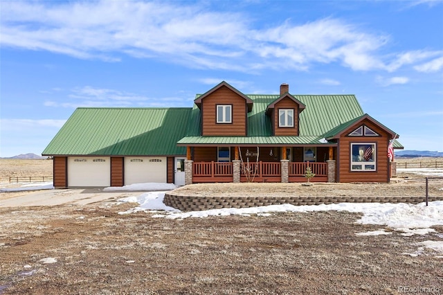 29 Howe Rd, Westcliffe, CO 81252 - view of front of house with covered porch, a chimney, concrete driveway, a metal roof, and an attached garage