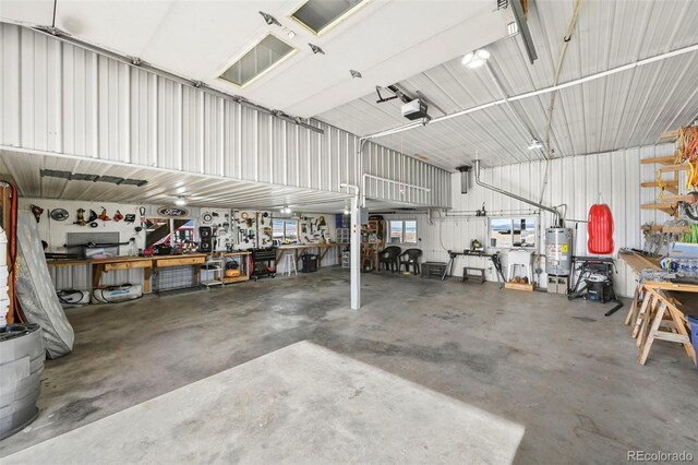 29 Howe Rd, Westcliffe, CO 81252 - garage with a workshop area, water heater, a garage door opener, and metal wall