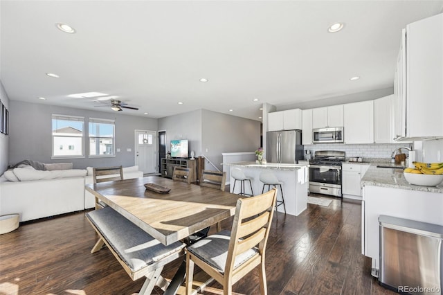 dining space featuring ceiling fan, sink, and dark hardwood / wood-style floors