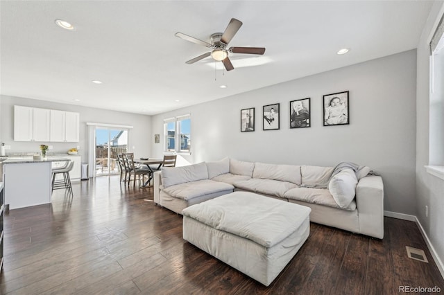 living room featuring ceiling fan and dark hardwood / wood-style flooring