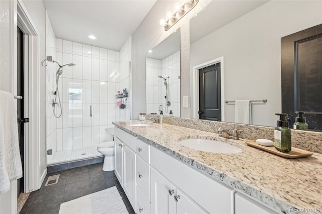 bathroom featuring tile patterned floors, vanity, an enclosed shower, and toilet