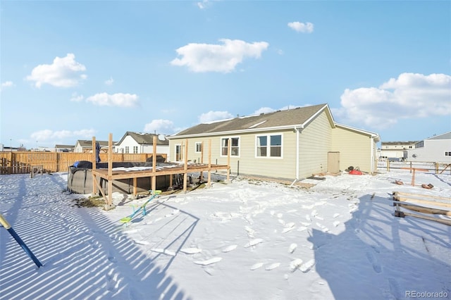 snow covered house featuring a deck