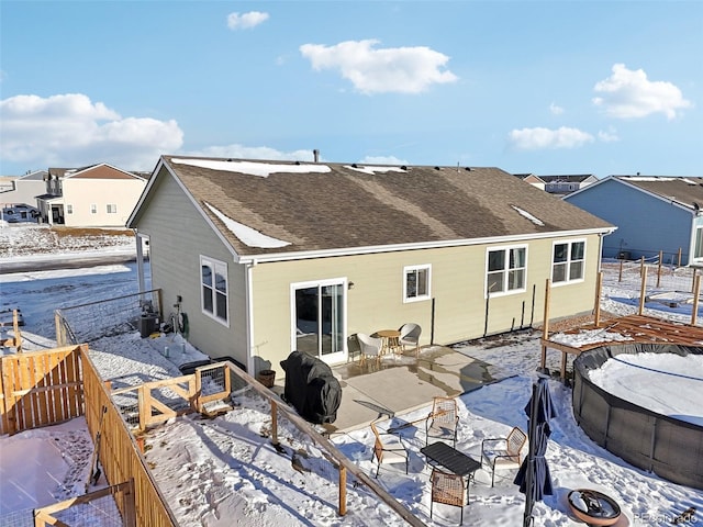 view of snow covered back of property