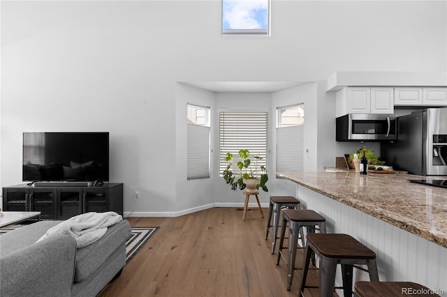 living room featuring light wood finished floors and baseboards