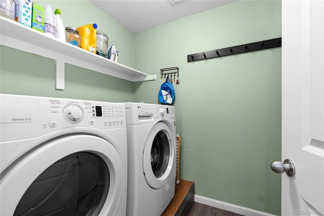 washroom featuring washing machine and clothes dryer, wood finished floors, and baseboards