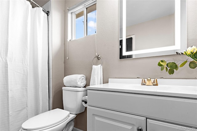 full bath featuring vanity, toilet, a textured wall, and a shower with shower curtain