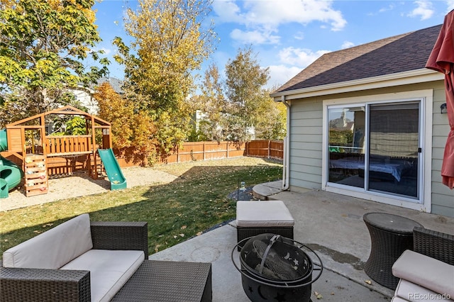 view of patio with a playground and an outdoor living space with a fire pit