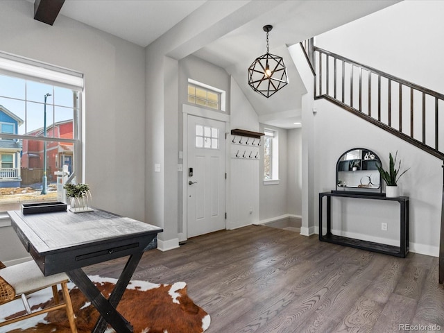 foyer entrance featuring high vaulted ceiling, dark hardwood / wood-style floors, a wealth of natural light, and a chandelier