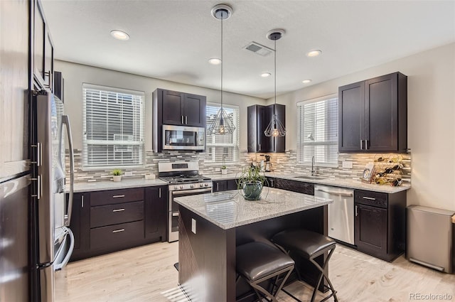 3795 Depew St Unit D, Wheat Ridge, CO 80212 - kitchen with stainless steel appliances, tasteful backsplash, light wood-style floors, light stone counters, and recessed lighting