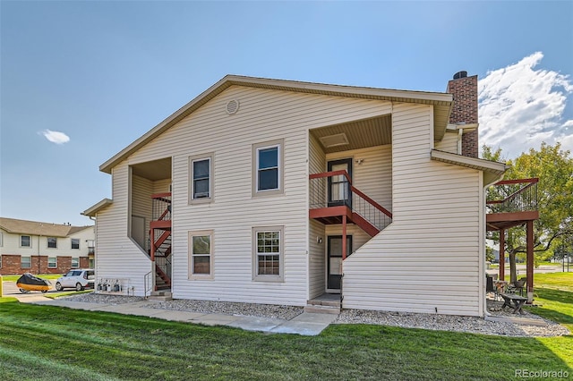 back of property featuring a yard and a balcony