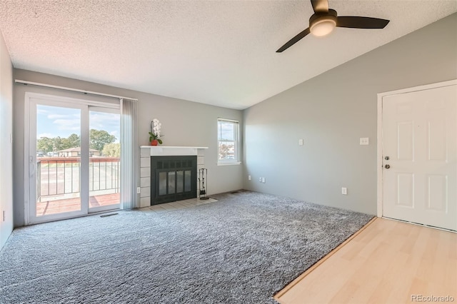 living room featuring lofted ceiling, ceiling fan, carpet, and a textured ceiling