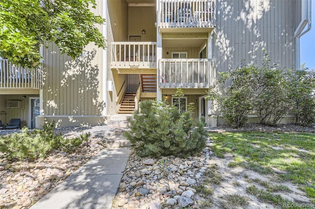 view of property featuring an AC wall unit and stairs