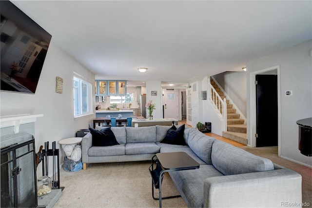 carpeted living room with stairway and a fireplace